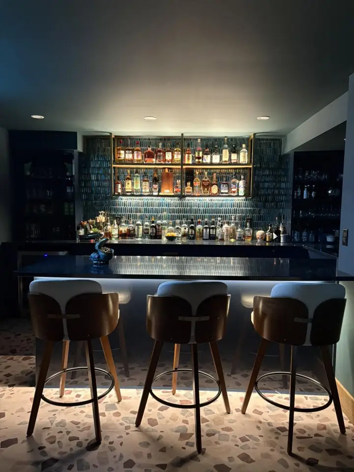 Custom interior bar with dark cabinetry and illuminated display
