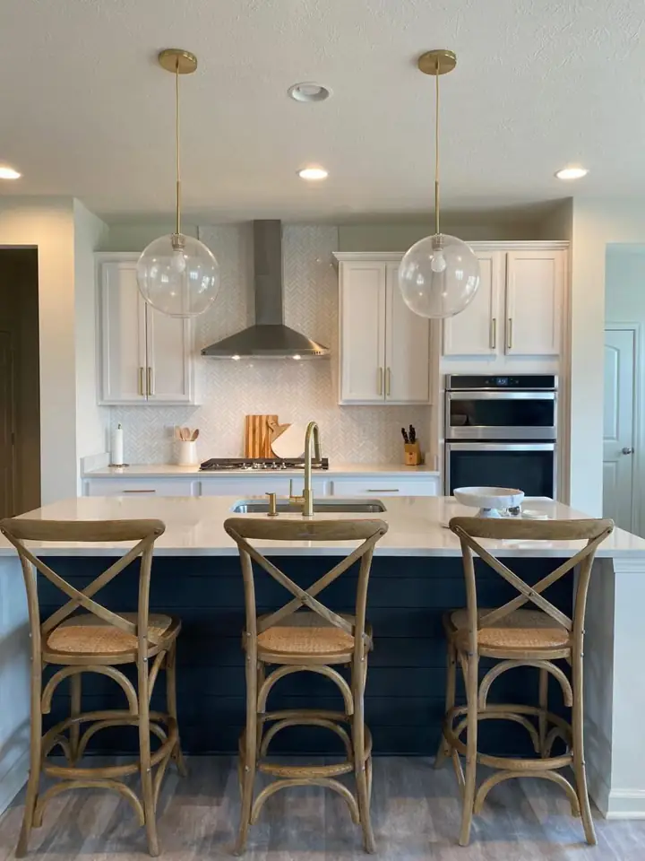 White kitchen renovation with dark island and pendant lighting
